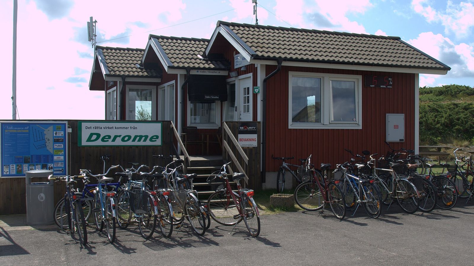 Rött hamnkontor i en småbåtshamn med cyklar parkerade utanför
