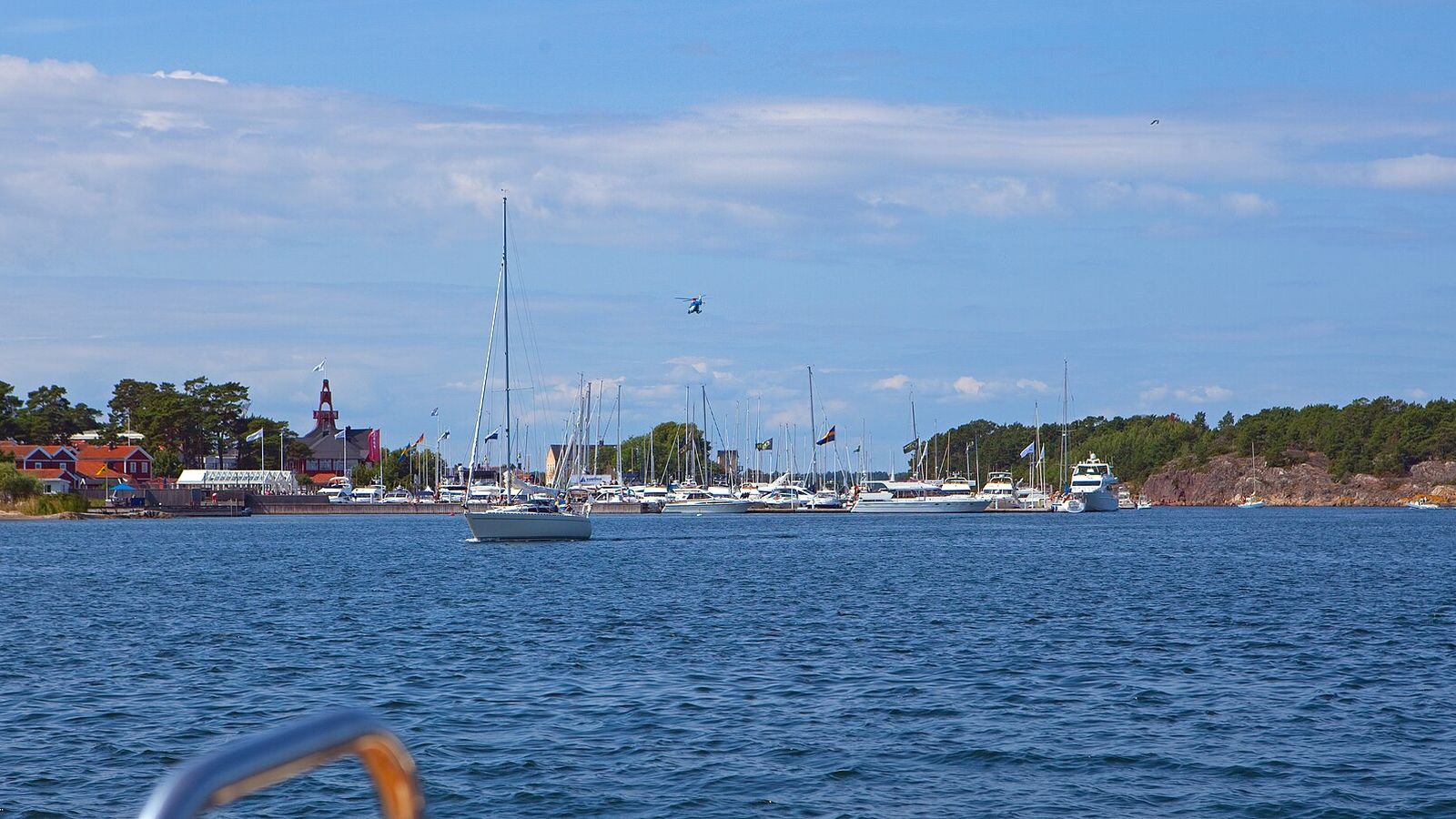 Sandhamn sett från vattnet med segelbåtar för ankar och bebyggelsen längs stranden