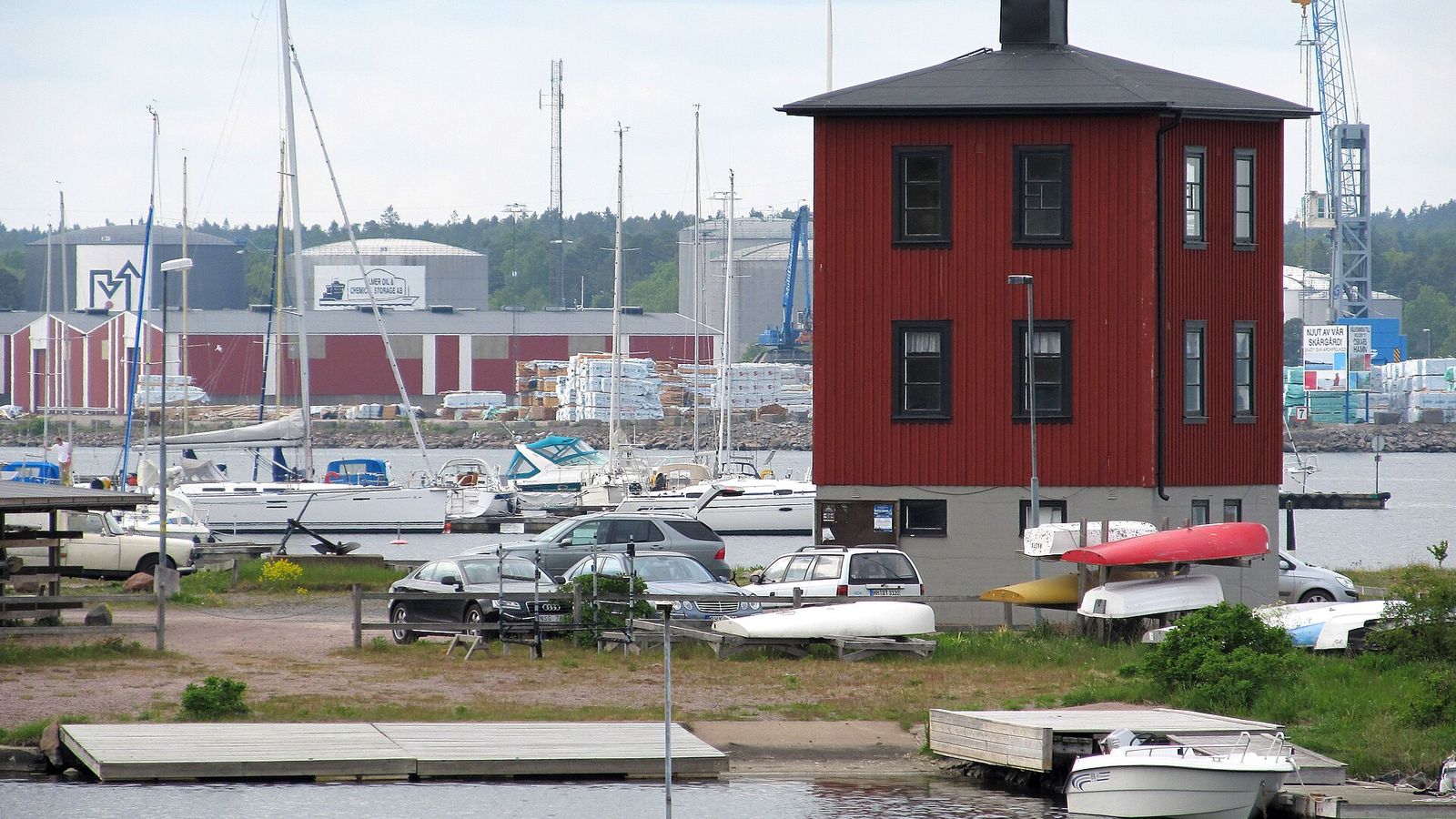Ernemar i Oskarshamn med småbåtshamn, röd träbyggnad och uppställda båtar