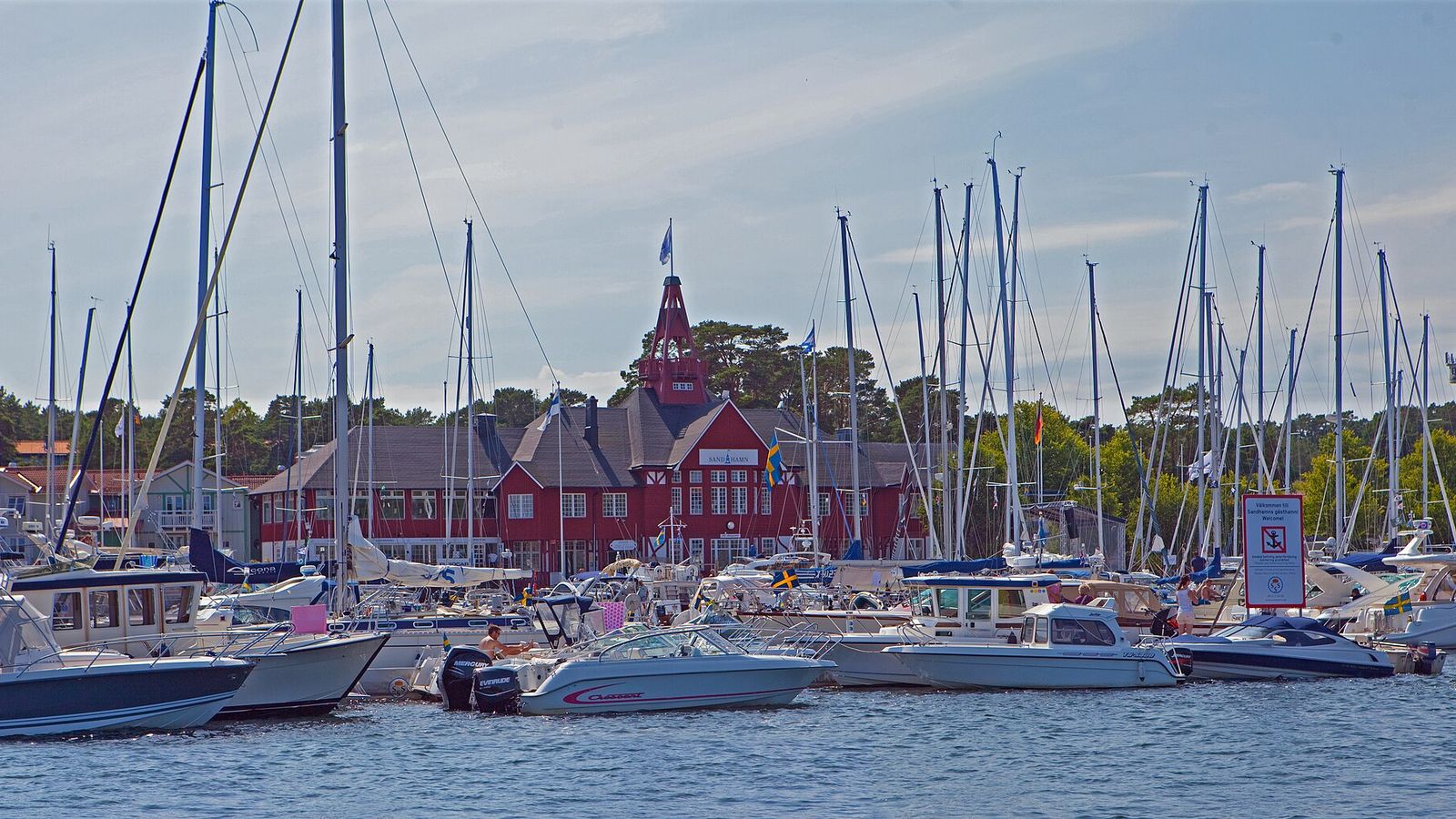 Gästhamnen i Sandhamn full av master framför Seglarhotellets röda fasad