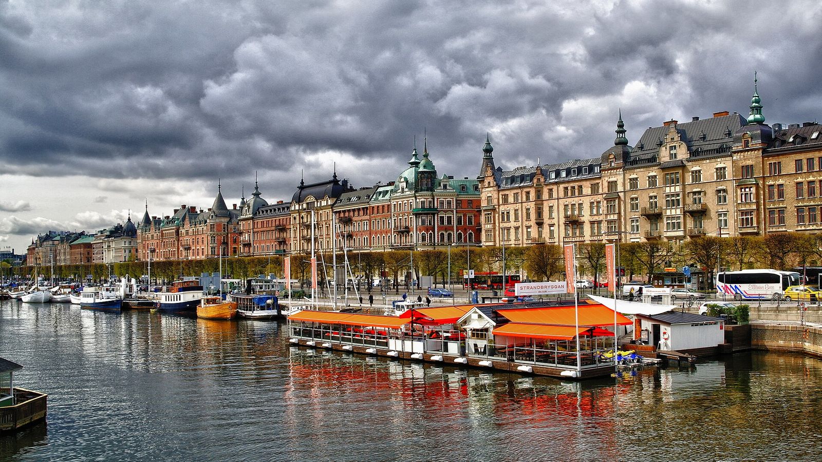 Strandvägen i Stockholm med stenhus från sekelskiftet och båtar längs kajen